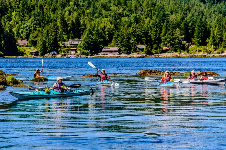 a group of people rowing a boat in a body of water