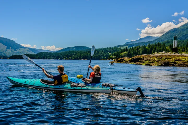 a group of people rowing a boat in a body of water